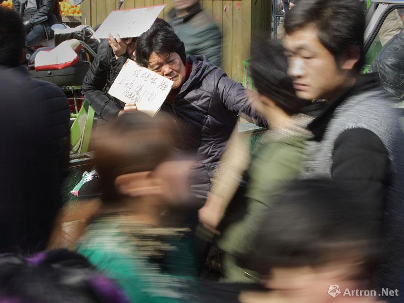 郭斌作品：2014年3月3日，一名招工的小企业主在人流中打瞌睡。
